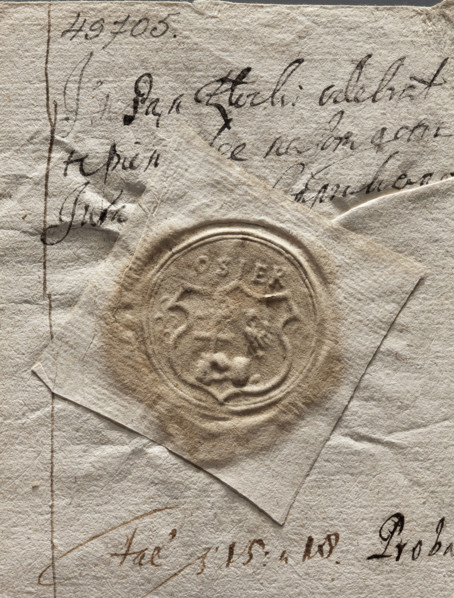 Round seal impression of the town of Osiek. On a decorative shield divided into a column: in the
