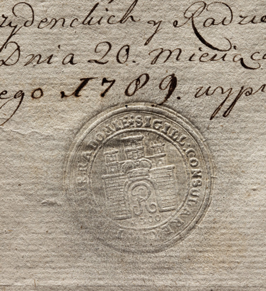 Round seal impression of the city of Radom. City wall with an open gate; in the gate the letter R,