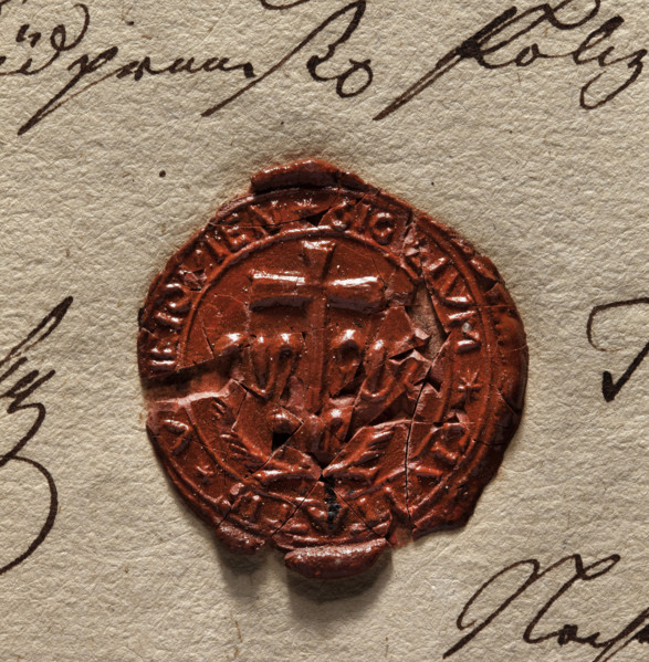 Round wax impression of the seal of the town of Uniejów. A cross standing on a lily, two palm