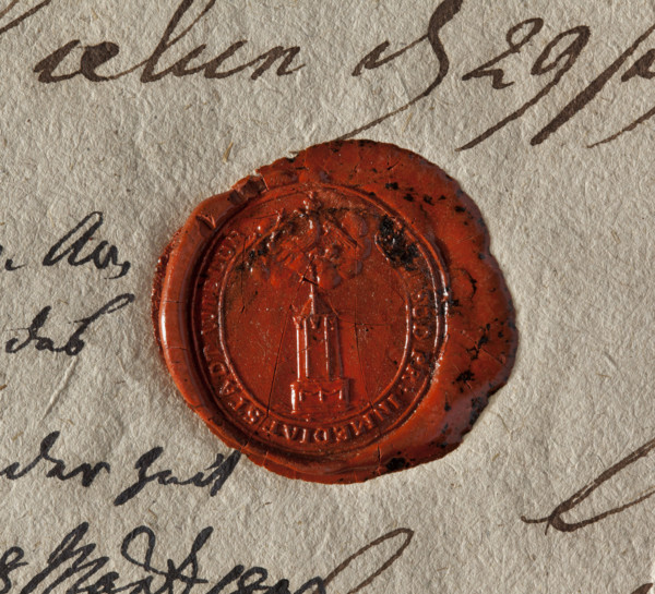 Oval wax seal of the city of Wielun. Obelisk on a pedestal decorated with garlands; a banner atop.