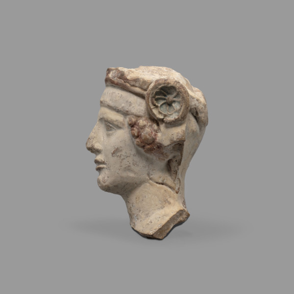 Head of a figurine of Dionysus. Head of a young man with a face devoid of [expression], wide