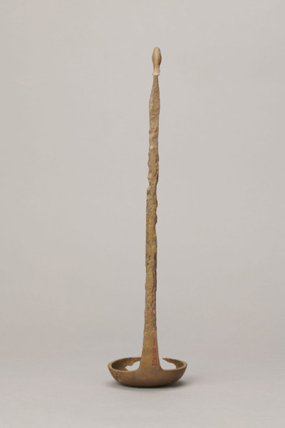 Shallow dipper with a quadrilateral handle, narrowed at the top. The end of the handle is in the