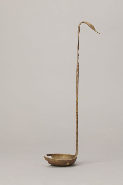 Shallow dipper with a quadrilateral handle, narrowed at the top. The end of the handle is in the