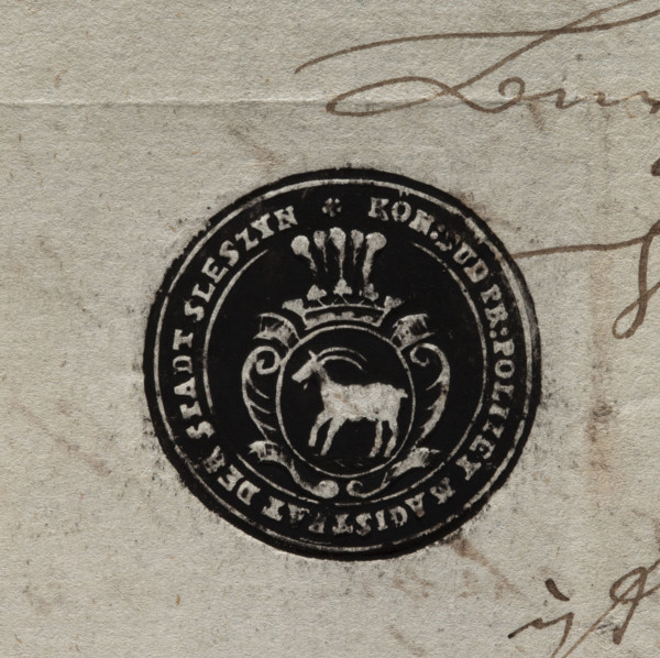 Round ink print of the seal of the town of Sleszyn. In a baroque cartouche, under an open crown