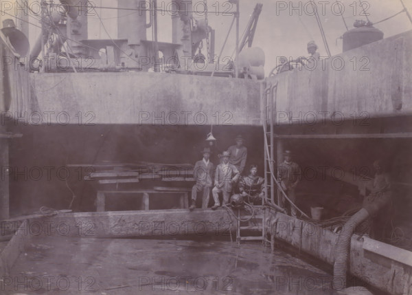 Japanese divers on hold II, photograph, A Japanese diving team poses at the edge of the hold of a