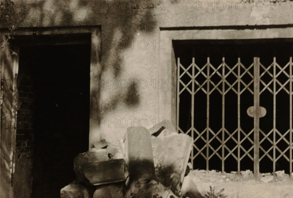 Enlargement of part of a ruin, with a sliding gate on the right and a doorway on the left,