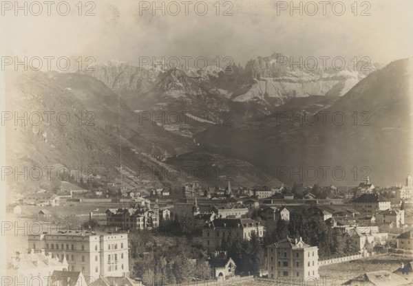 Landscape with mountains and a city, album page, photograph, This photo is part of an album.,