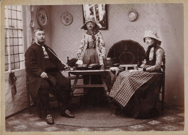 Portrait of an unknown man and two unknown women in traditional costumes from Hindeloopen,