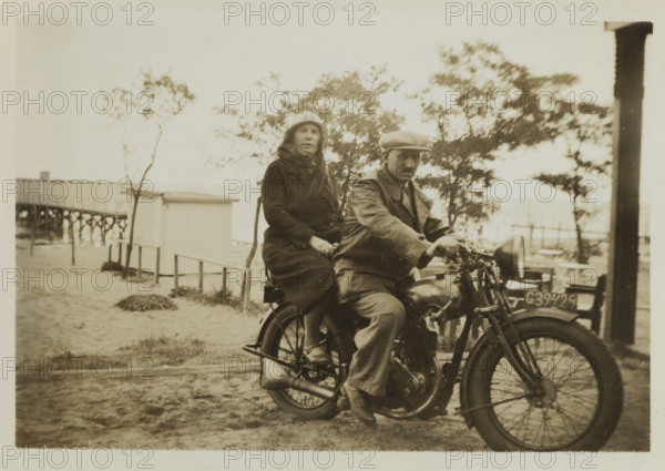 Wilhelm Ochse and Catharina Maria Groennou on a motorcycle on the beach of Valkeveen, photograph,