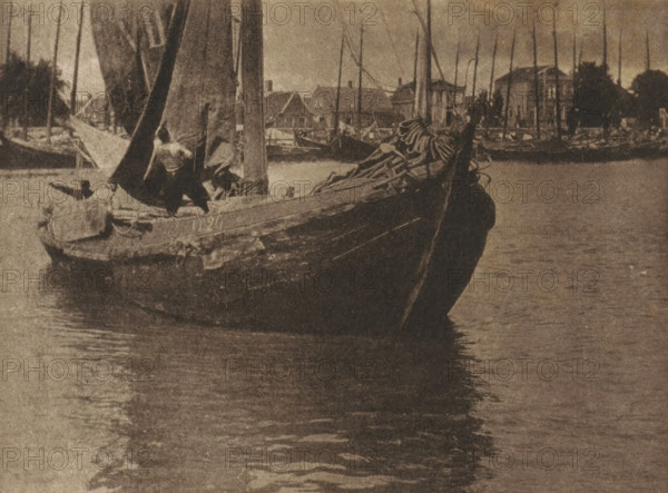 Sailboat setting sail with the sail being hoisted, page, photomechanical print, inscription: 'GB.