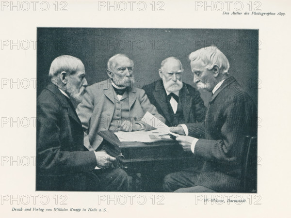 Four men at a table, page, photomechanical print, inscription: 'Das Atelier des Photographen.',