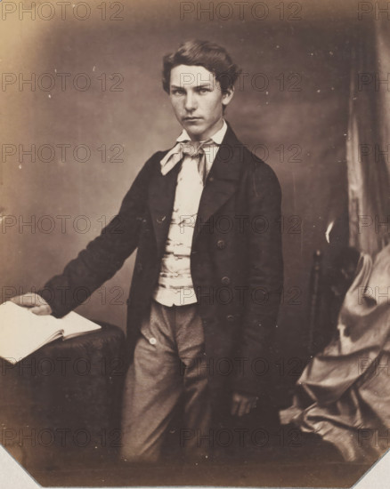 Portrait of an unknown standing young man with hand on book, photograph, photographer: attributed