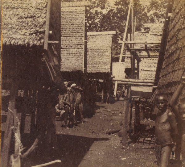 View of a village street with groups of children on one of the Tanimbar Islands, Tenimber Islands.