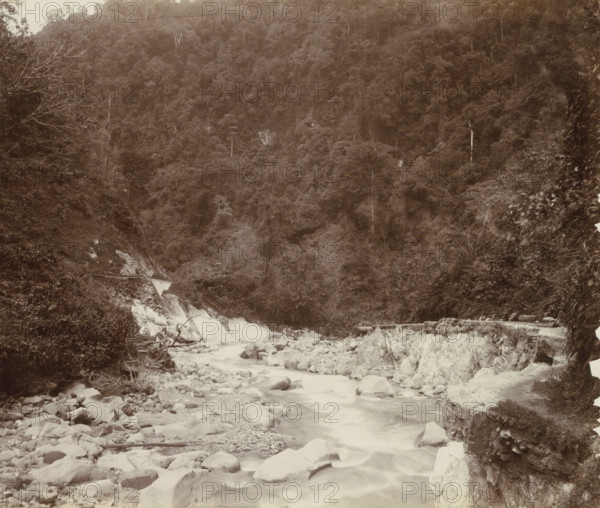 Stream with a road alongside it and workers in the Dutch East Indies, album page, photograph, Part