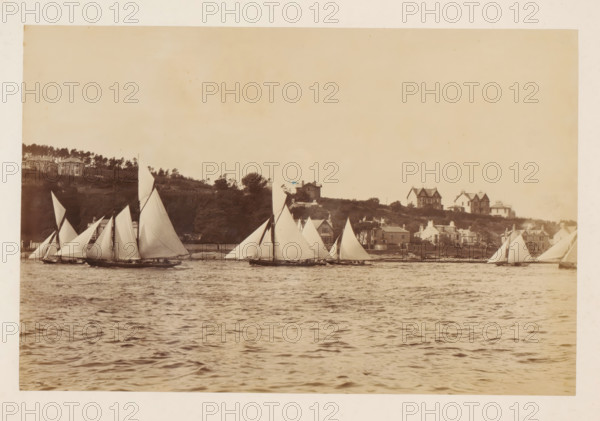 Various sailing ships on the water with buildings in the background, album page, photograph, This