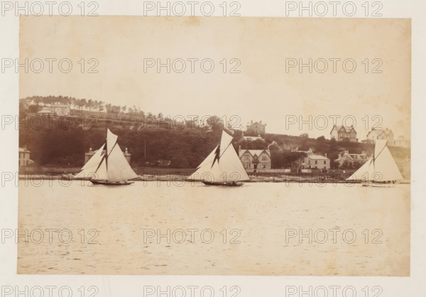 Three sailing ships, including the Coila, at sea with a landscape with buildings in the background,