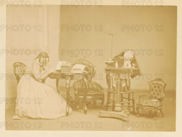 A little boy plays at a table, while a girl reads at another table, photograph, page, photographer:
