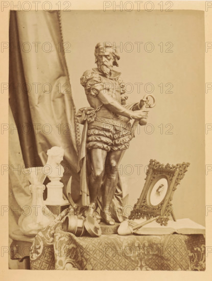 Bronze sculpture, photo frame, pipe and other items on a table, photograph, page, photographer: