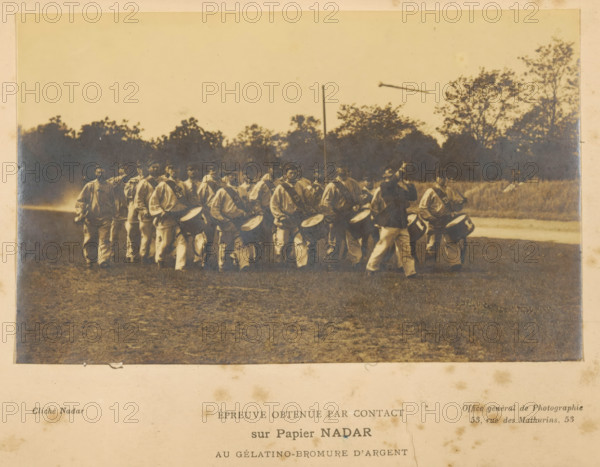 View of a group of unknown men with, among other things, drums, photograph, page, inscription: