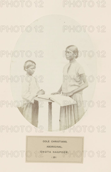 Praying boy and a girl with a book behind a desk from Chota Nagpur in eastern India, photograph,
