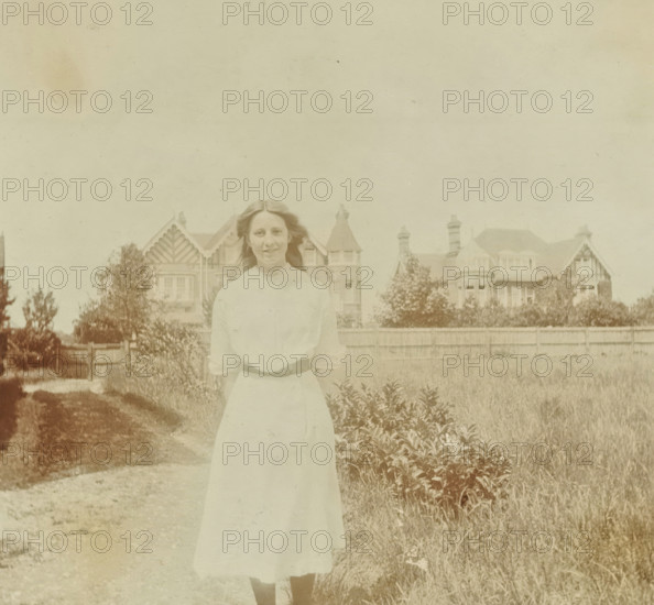 Marjorie in a rural setting with a building in the background in Bexhill-on-Sea in England, 1913,
