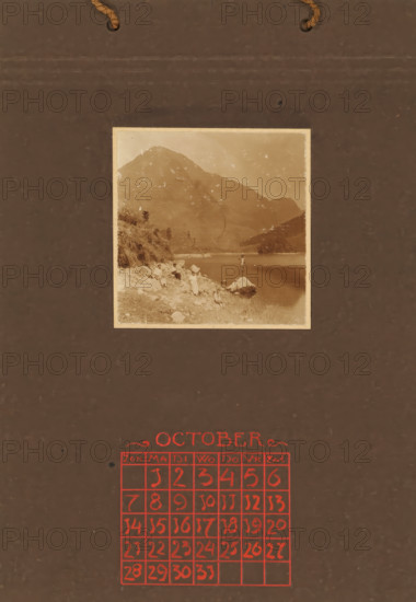 Three women, a man and two children on rocks on the coast, with a mountain in the background, album
