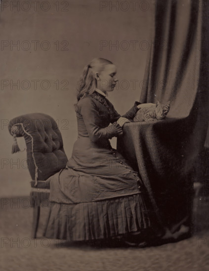 Portrait of an unknown young woman sitting at a table with a cat, photograph, 1855 - 1900,