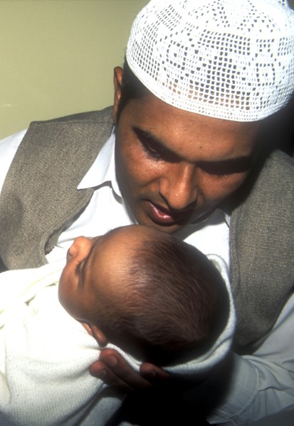 Father whispers opening words of the Muslim prayer in his newborn baby`s ear