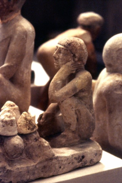 Man kneeling before loaves of bread