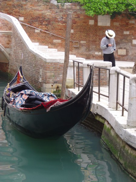Venice. Gondolier alongside the quay Palace Dario