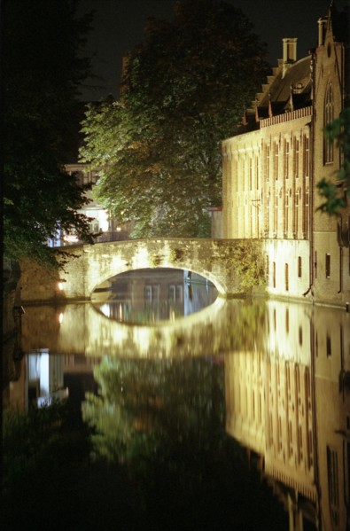 Bruges de nuit : maisons sur le canal, pont et quai, reflets dans le canal, en automne