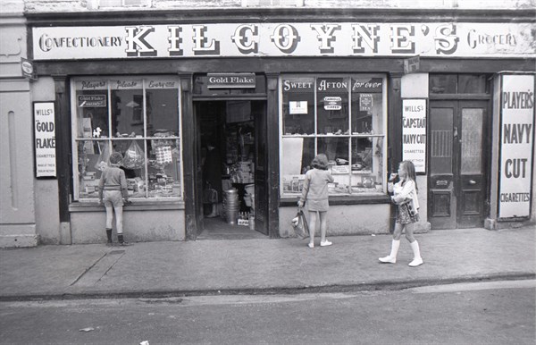 Enfants regardant la vitrine d'une épicerie en Irlande
