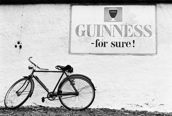 Bicyclette contre le mur d'un pub, sous une publicité pour la bière Guinness.
Comté de Kildare,