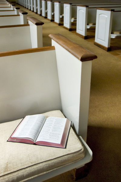 Interior of a church with Bible on a pew.