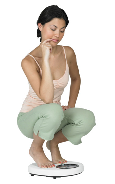 A woman weighing herself on a scale.