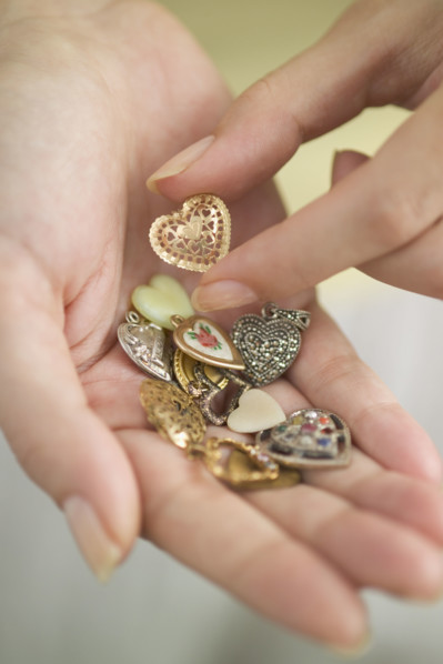 Woman holding a handful of hearts-shaped vitamins.