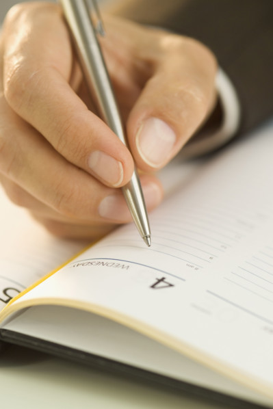 Man writing in an appointment book.