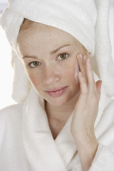 Woman applying face cream.