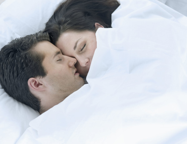 Couple asleep in bed.