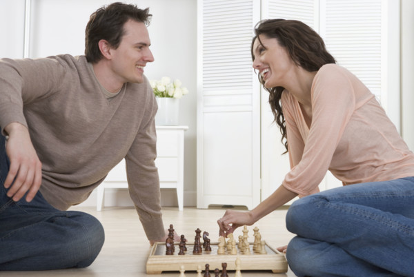 Smiling couple playing chess.