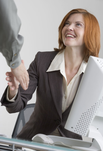 Businesswoman shaking hands with colleague.