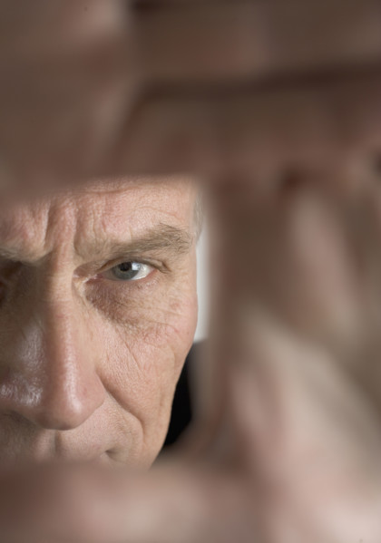 Hands framing face of a man.