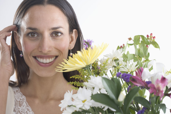 Woman holding bouquet of flowers.