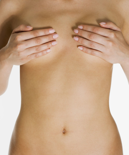 Nude woman holding hands over breasts.