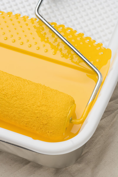 Still life of paint roller with yellow paint.