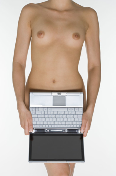 Nude female holding laptop computer.