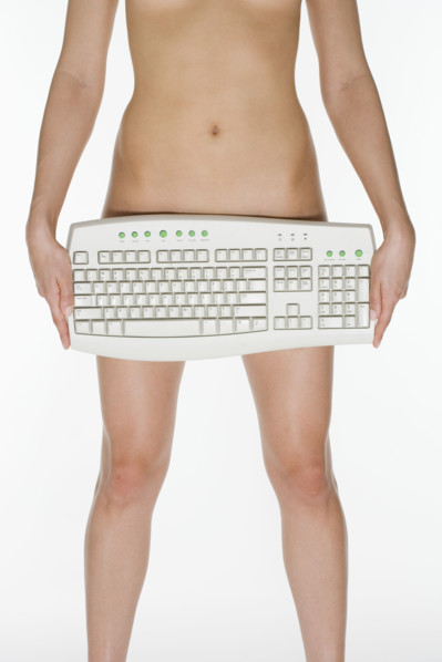 Nude female holding computer keyboard.