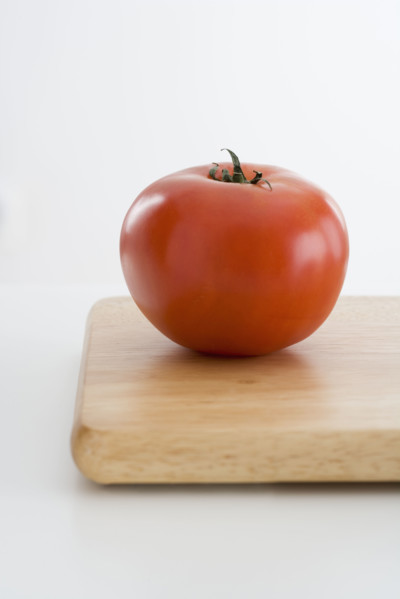 Fresh tomato on cutting board.