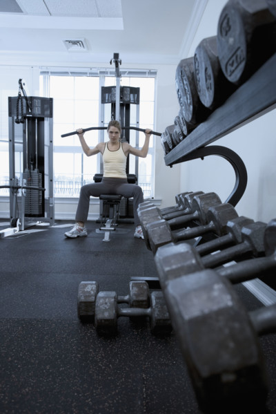 Woman working with resistance machine.