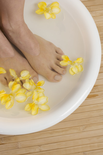 Feet in footbath with flowers.